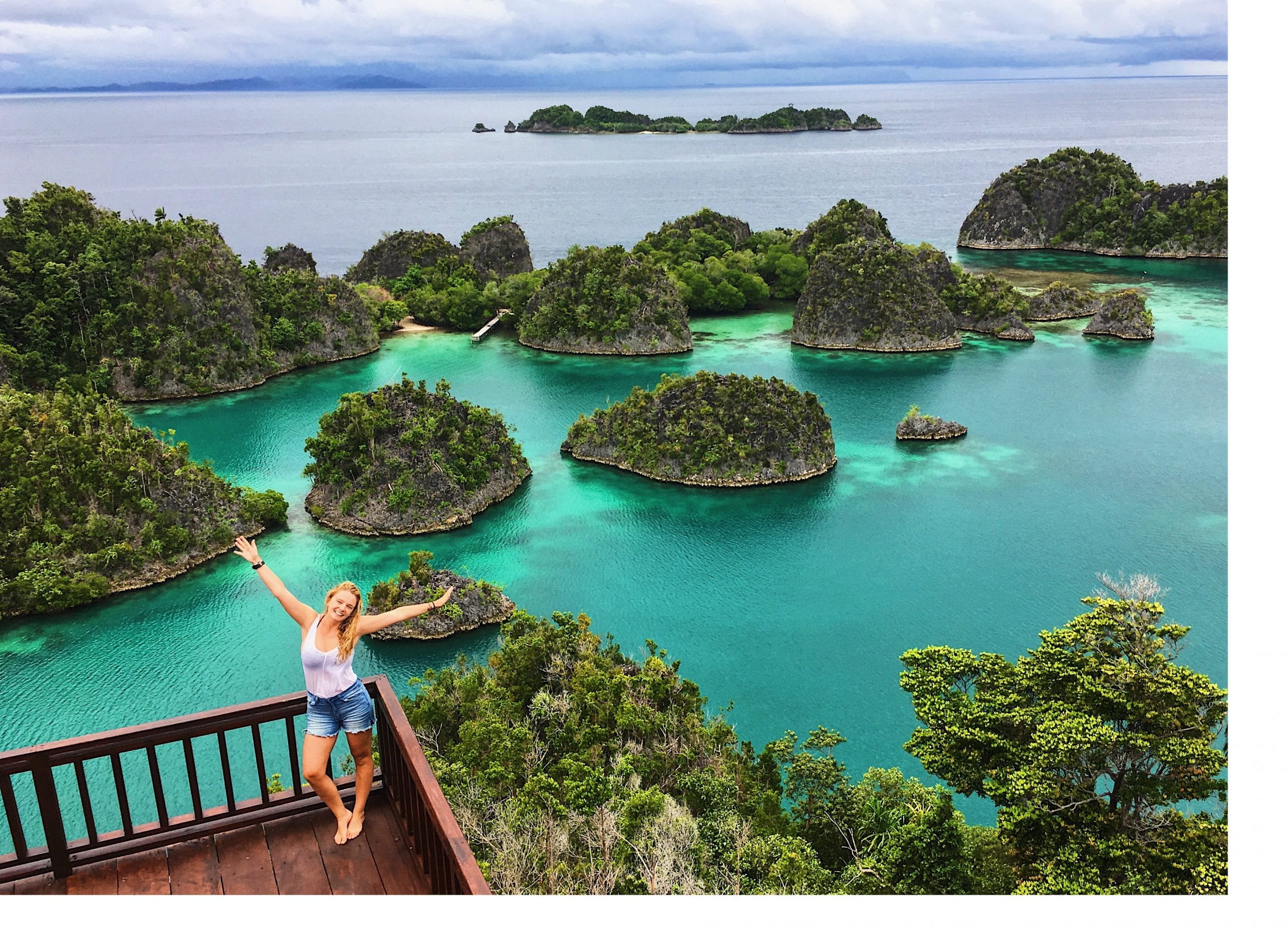 Chloe King stands on a balcony overlooking a series of small islands in Raja Ampat, West Papua