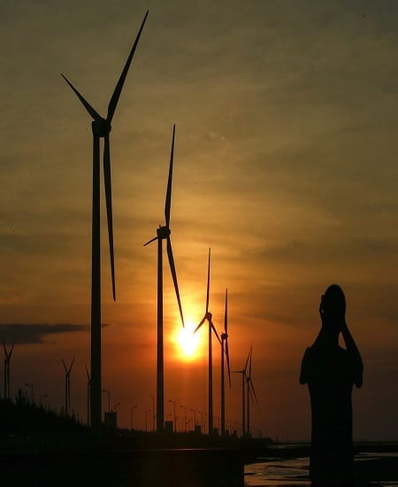 wind turbines in Taiwan at sunset, with silhouette of person taking pictures