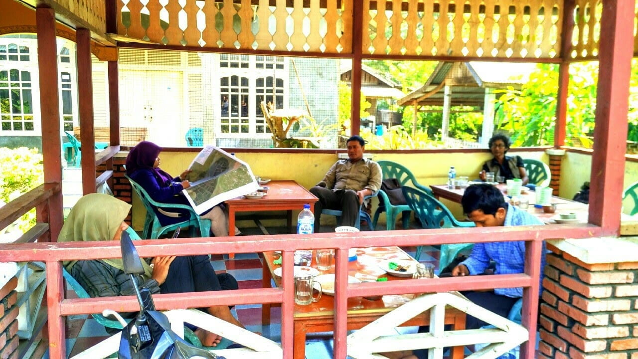 customers sitting at an outdoor coffee shop in indonesia