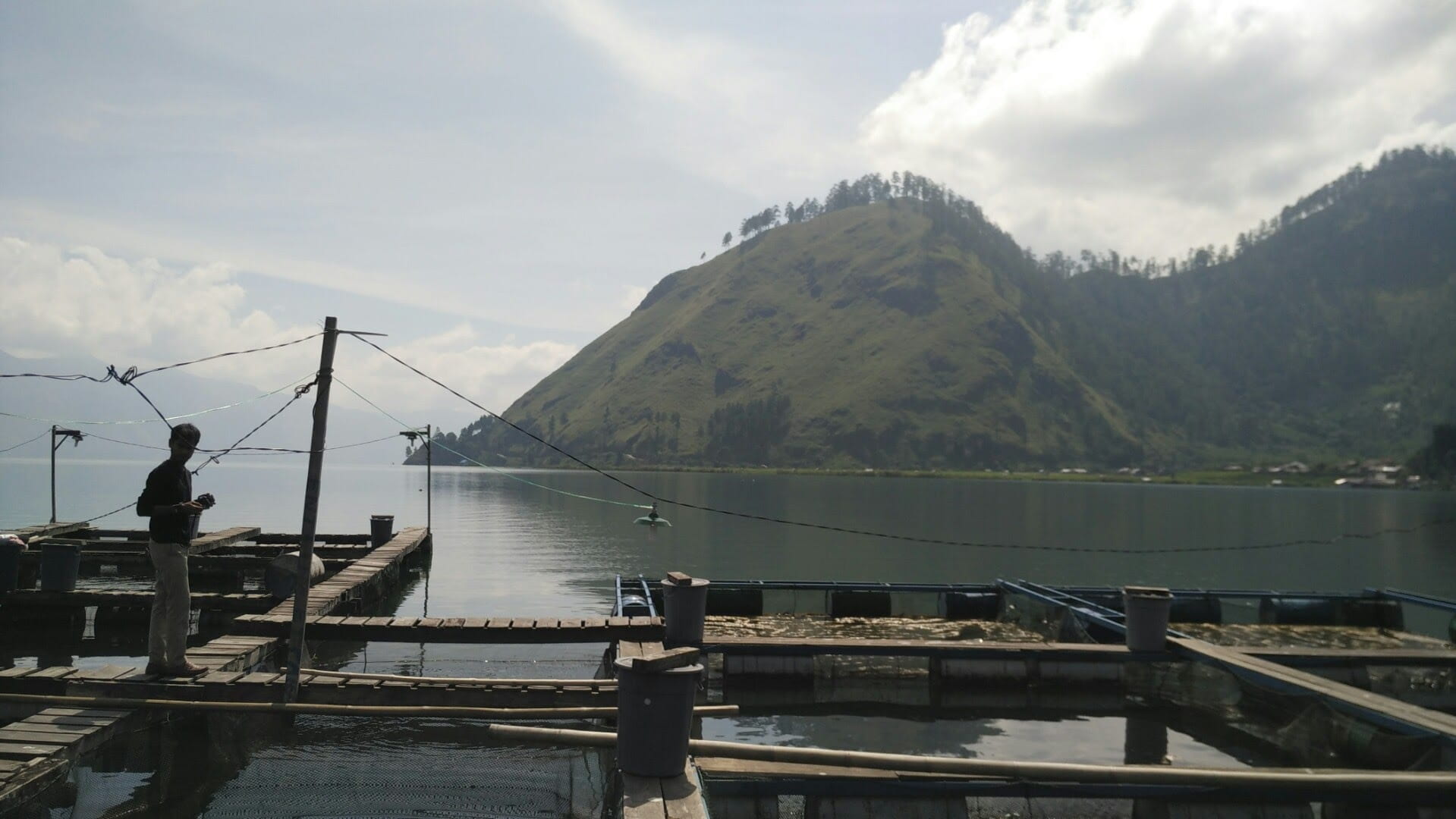 fish farm at a lake with mountains in the background