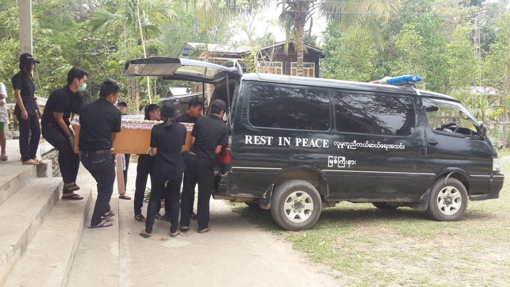 a team of people loading a coffin to its free-of-charge funeral transportation van