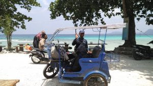 person posing on a cart near a beach in indonesia
