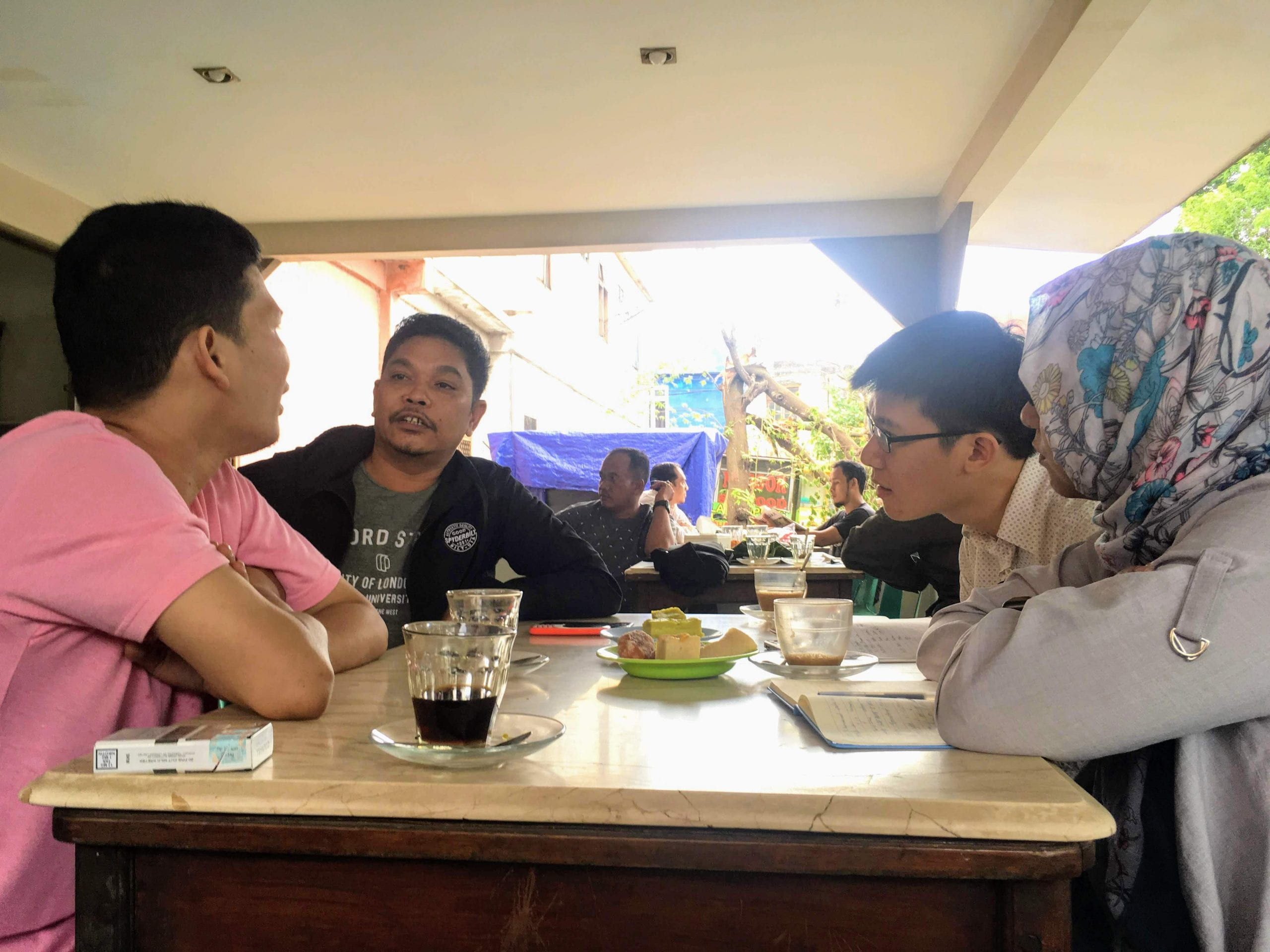 author having a discussion with local Indonesian human rights activists at a coffee shop