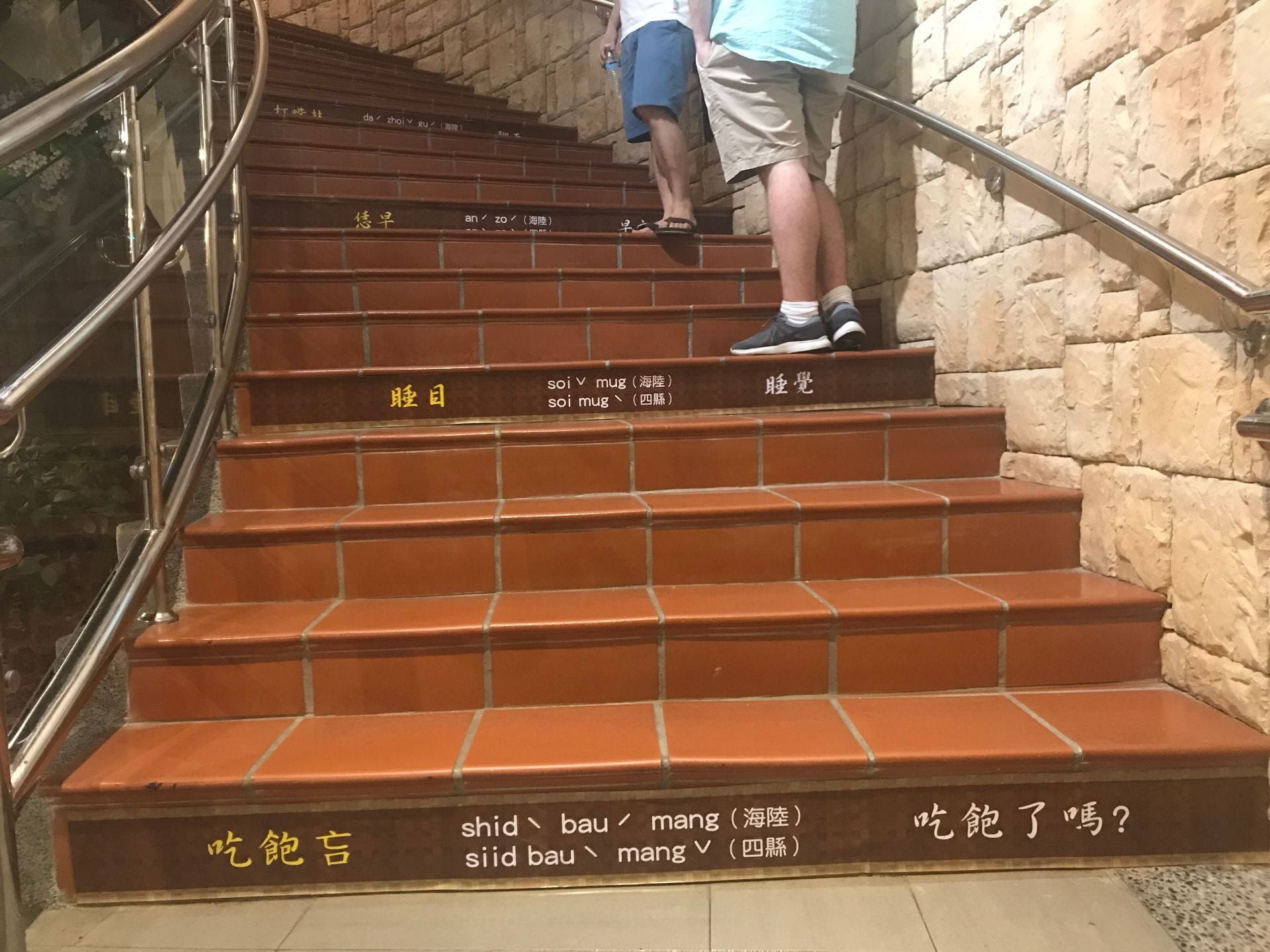 Flight of stairs with terracotta colored tiles with chinese text on the side