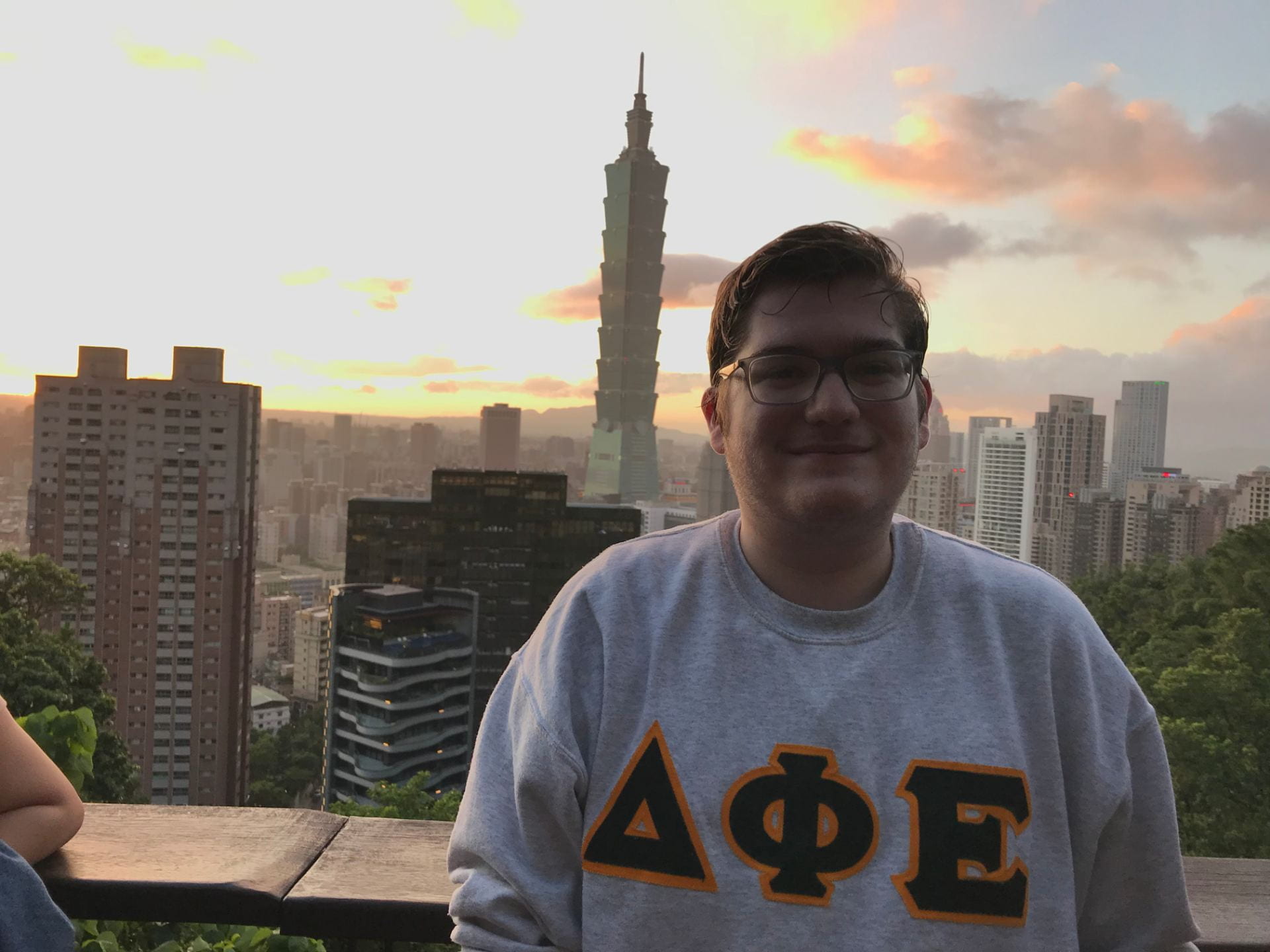 Sigur language student poses in front of skyline of Taiwan