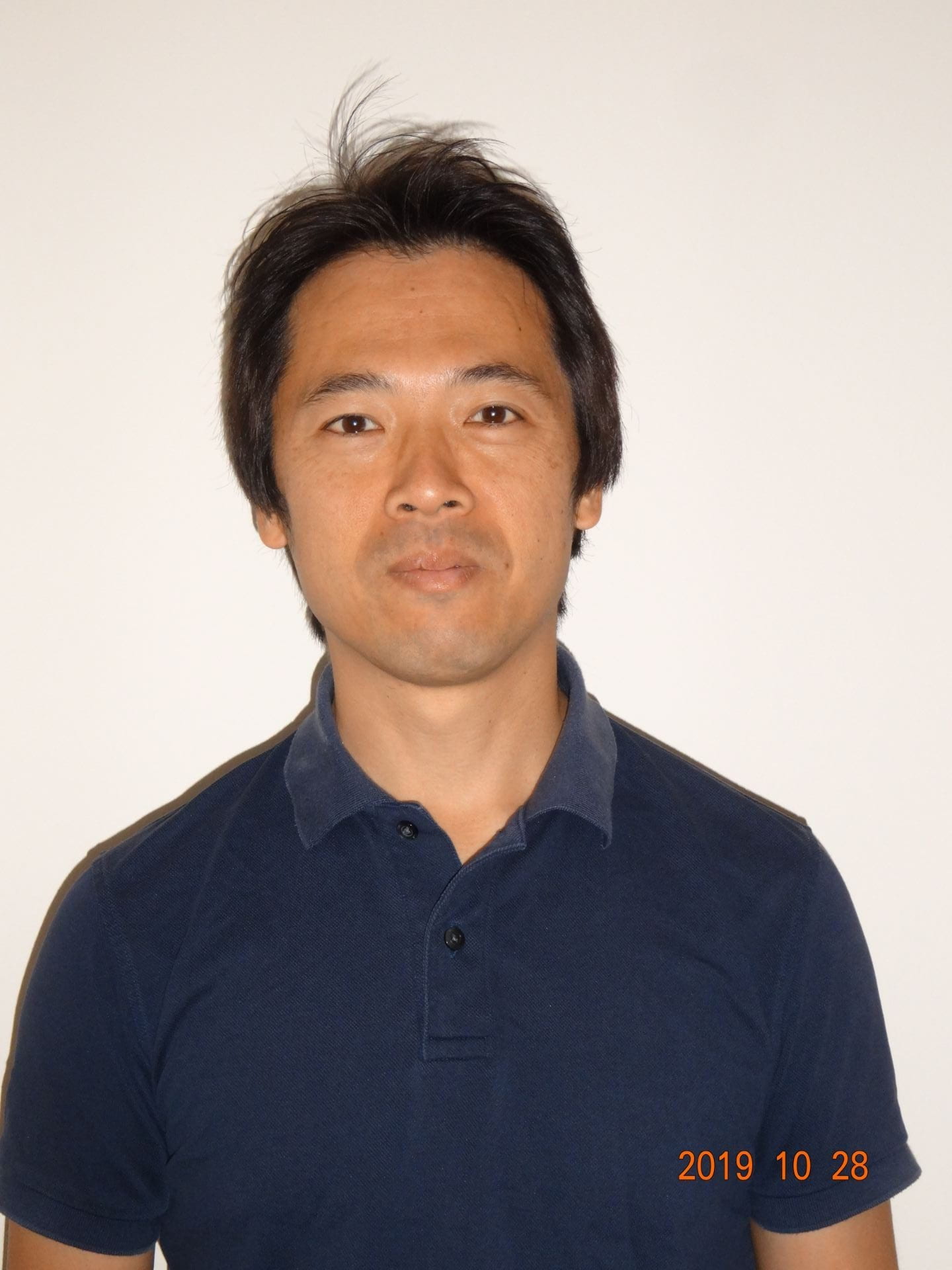 headshot of Keikichi Takahashi in dark blue polo shirt