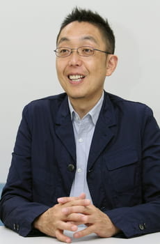 Nobuyuki OKumura poses in professional clothing against a white background
