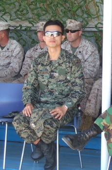 park junyong sitting in a chair outdoors in his military uniform