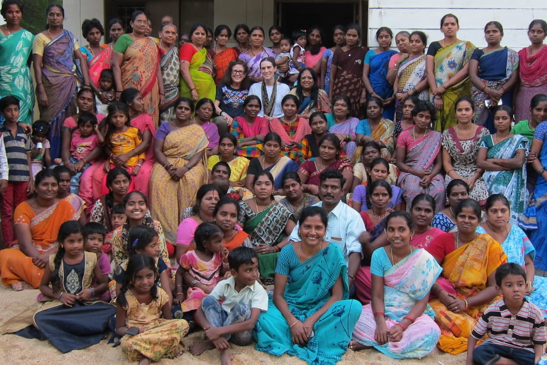 group photo with a lot of women and children in traditional South Asian clothes