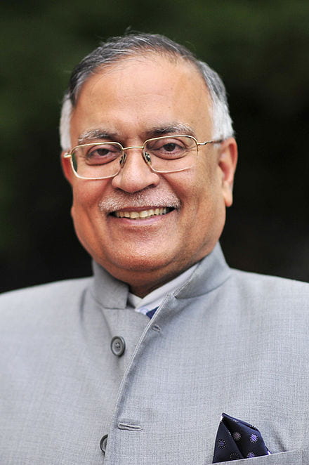 headshot of pradeep kapur smiling with black background