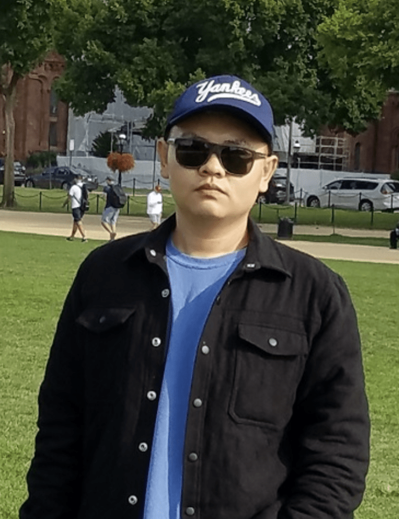 Shengsong Yue posing on the National Mall in casual attire