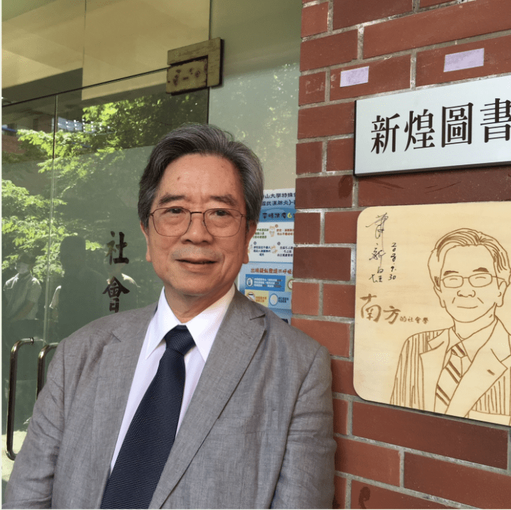 Dr. Hsin-Huang Michael Hsiao posing with a portrait of a Taiwanese figure outside a library in Taiwan