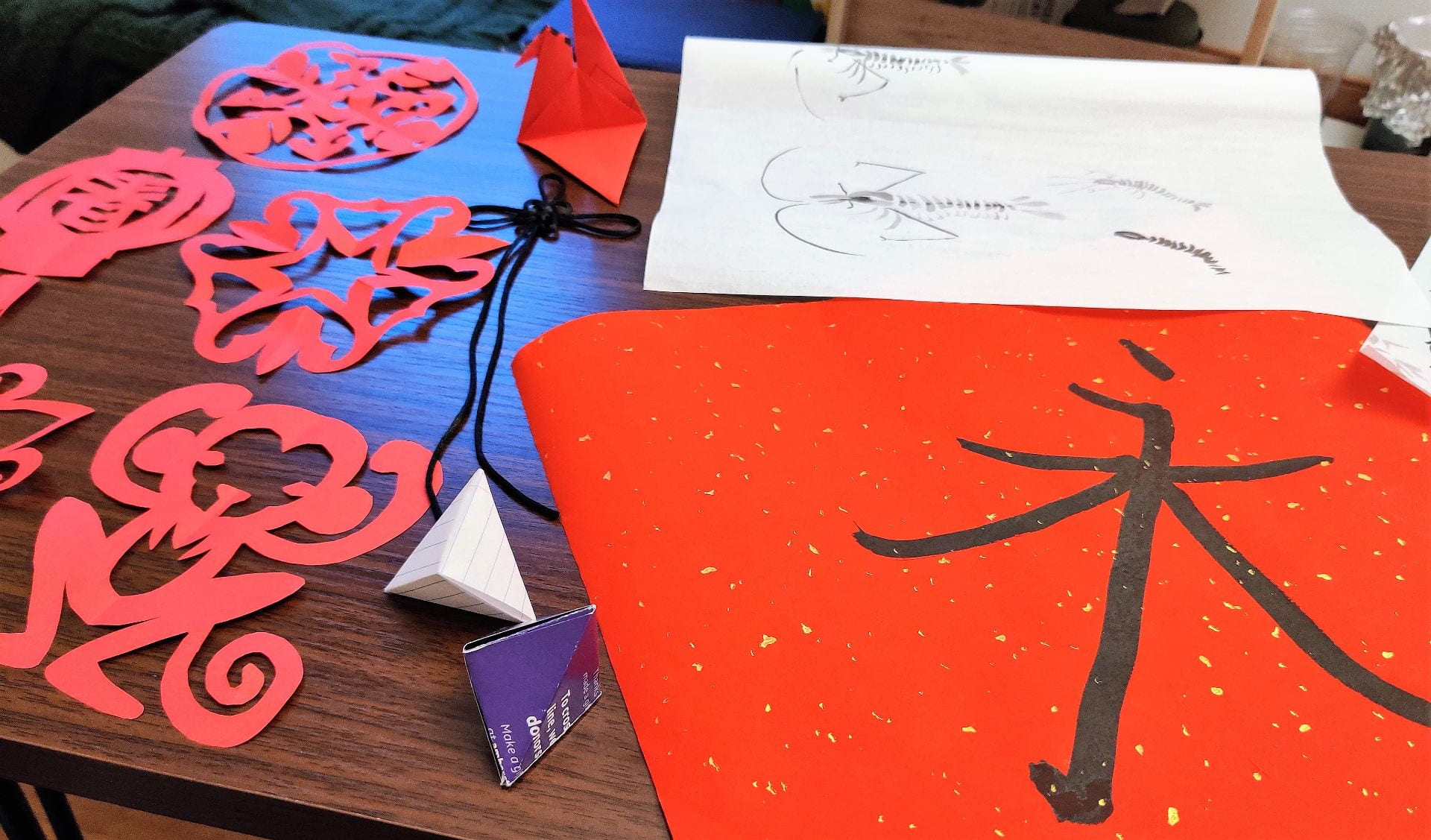 red paper cutouts on the table with Chinese calligraphy on red paper
