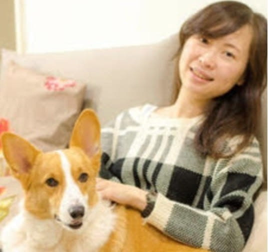 Mei-chun Lee posing for photo on a couch with her dog
