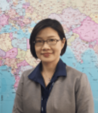 portrait of Liang-Yu Wang standing in front of a word map