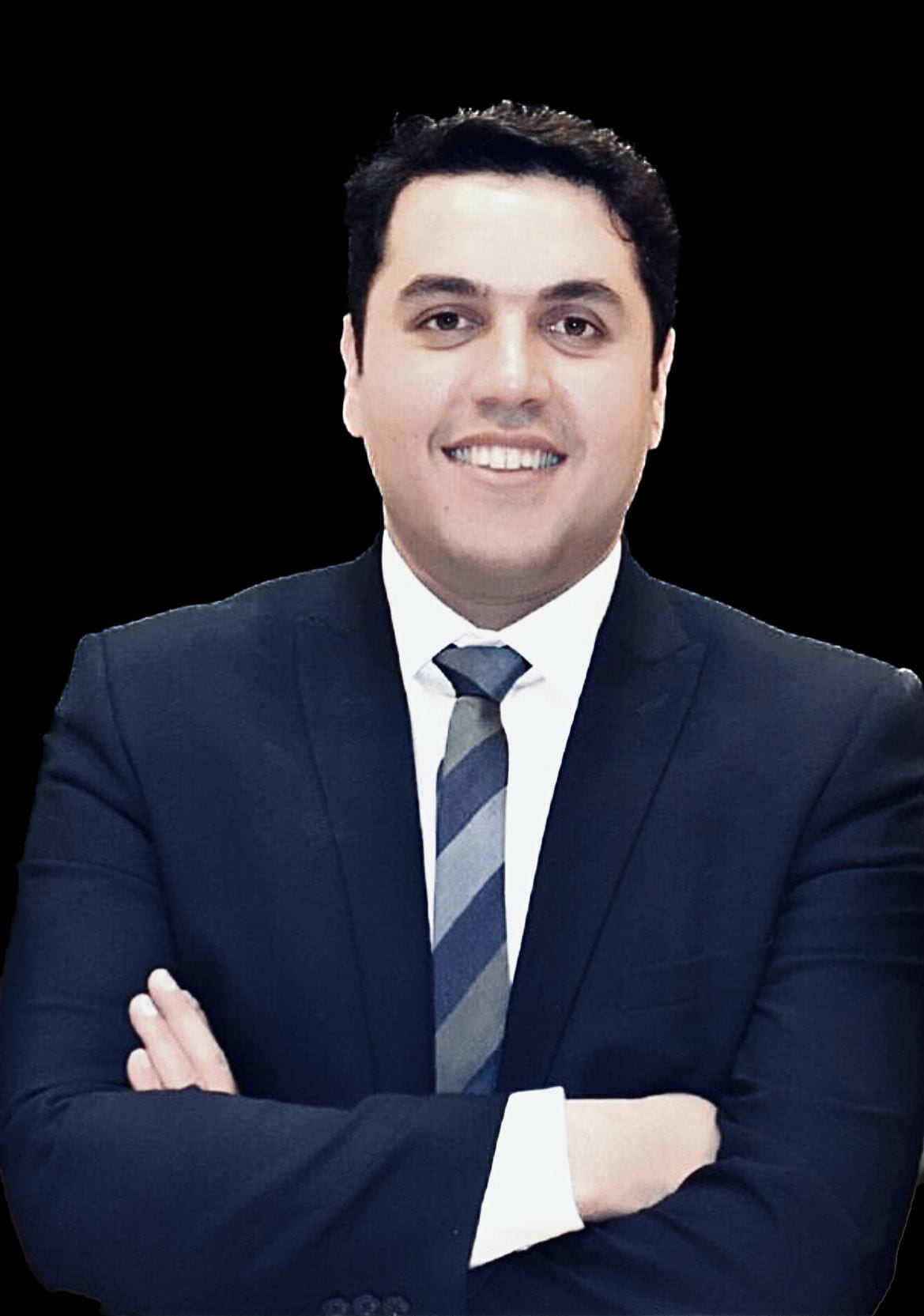 A picture of Haroon in a suit and tie, smiling at the camera